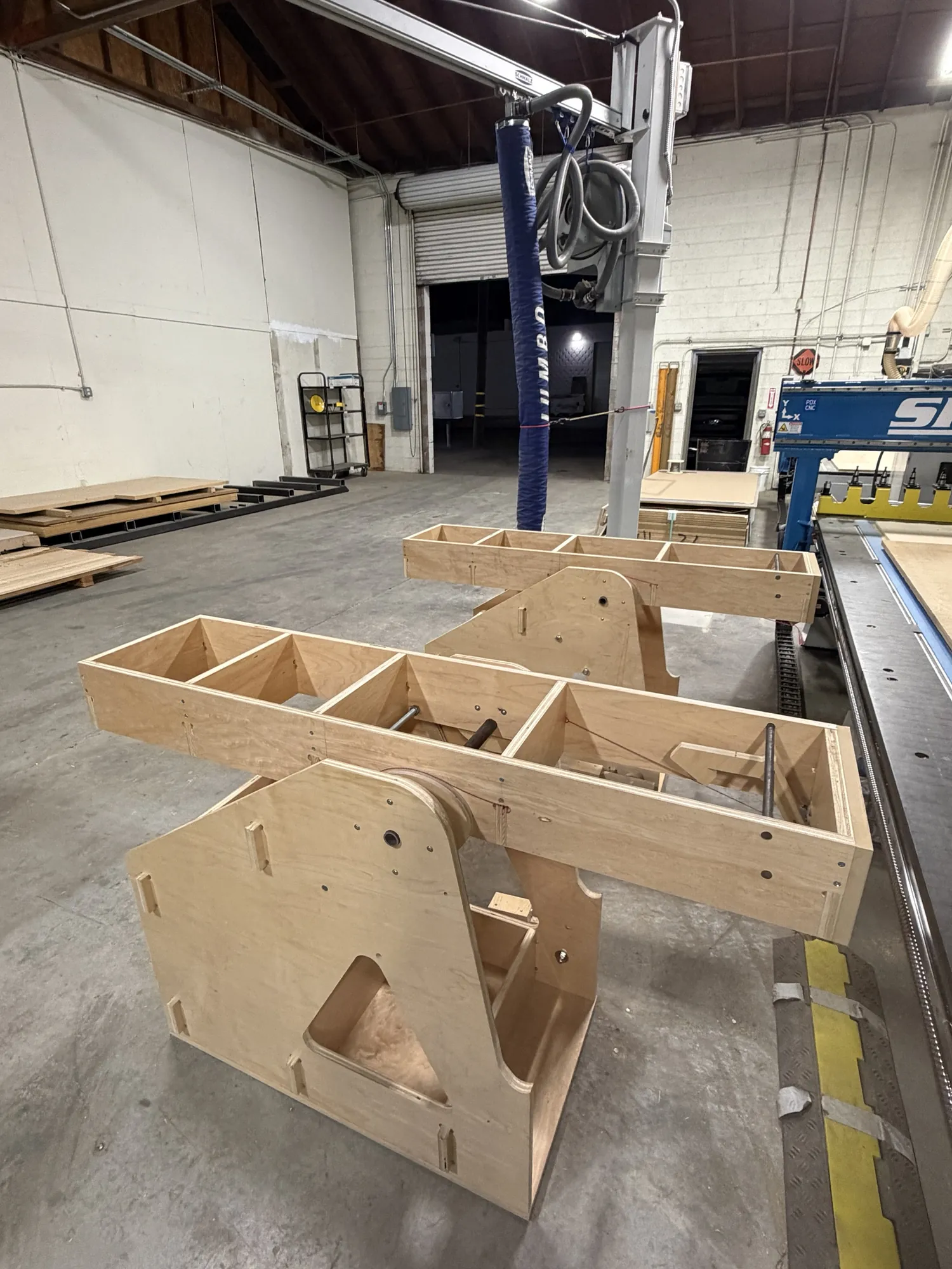 Both flipper stands in the shop with the wings level, the walkway between them, beside the CNC table.